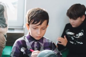 gambar seorang anak sedang belajar di kelas. Gambar dipakai pada website Klinik Utama Dr. Indrajana untuk halaman Tes Iq.