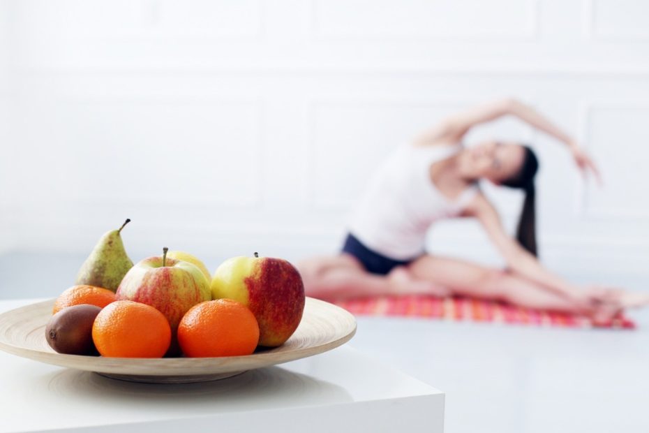 gambar buah dengan background wanita sedang melakukan yoga.