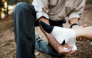 gambar seseorang sedang membalut kaki saat sedang olahraga. Gambar dipakai untuk artikel Klinik Utama DR Indrajana membahas patah tulang.