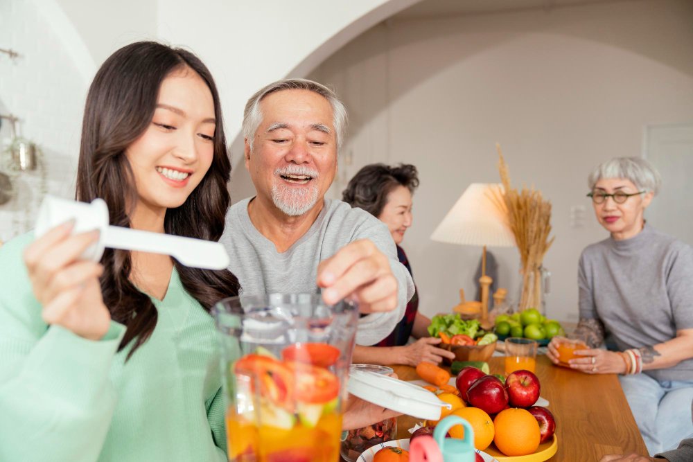 gambar keluarga sedang makan makanan sehat. Ini dipakai untuk artikel membahas mencegah pengapuran tulang