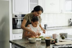 seorang ibu dengan anaknya sedang melakukan pola hidup sehat untuk mencegah flu saat musim hujan.